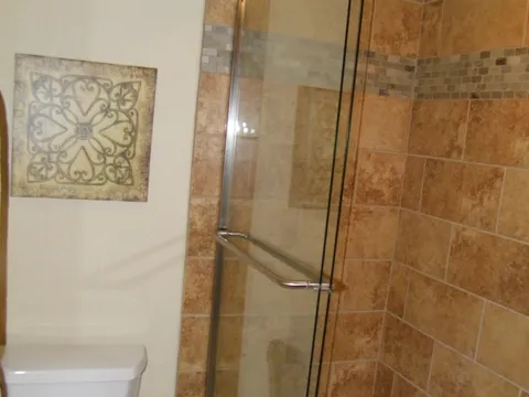 Tiled shower and tub enclosure with glass sliding doors