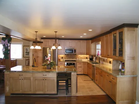 Maple kitchen cabinets with dark crown molding and granite countertops