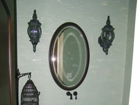 Sculpted copper vessel sink on a pedestal stand in a powder room