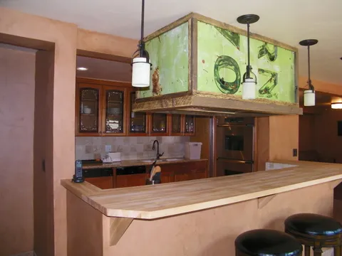Leaded-glass cabinets and a stainless fridge in a farmhouse-style kitchen