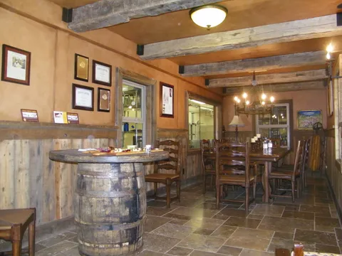 Rustic dining room with a stone-tile floor and plank walls