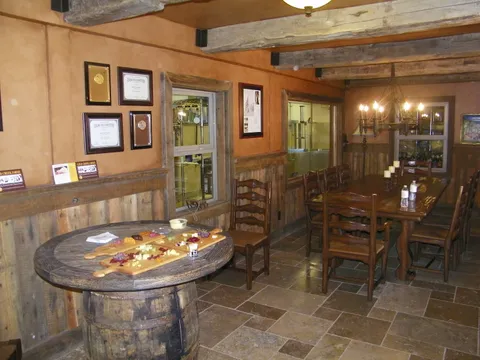 Stucco-finished column dividing a lounge with black leather bar stools