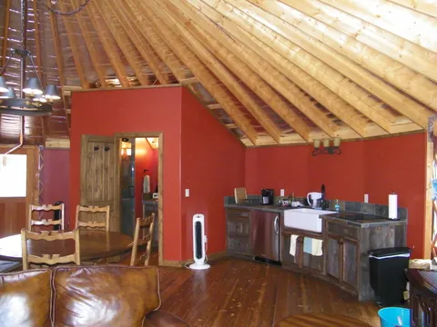 Farmhouse sink and wood cabinetry in a yurt kitchenette