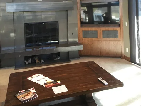 Living room with a tiled fireplace and built-in wood media cabinet