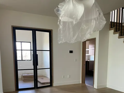 Room with dark-framed glass doors and wide plank flooring
