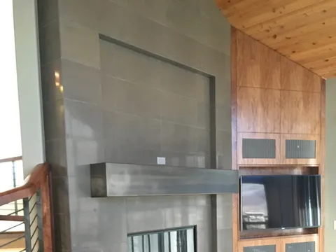 Living-room stacked-tile fireplace with a wall-mounted TV and built-ins