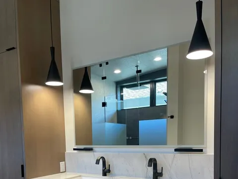 Double-sink vanity with gray cabinetry and under-cabinet lighting