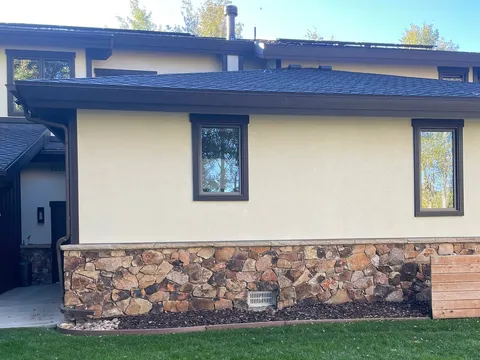 Single-story home exterior with stone veneer and a wide lawn