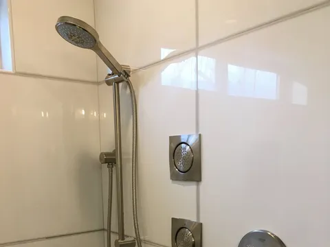 Chrome showerhead and controls on white tile