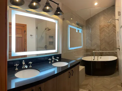 Bathroom with double vanity, freestanding tub, and tile floor