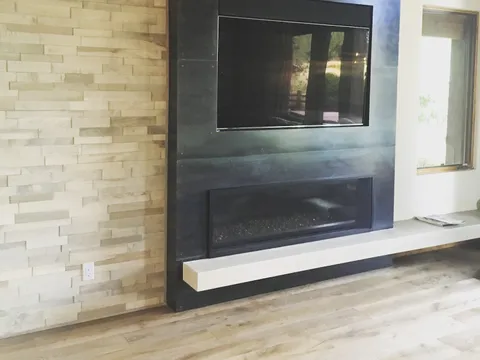 Modern fireplace with a dark metal surround and a mounted television